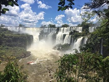 Scenic view of waterfall against sky