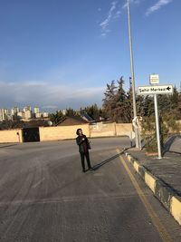 Full length of man on road against sky in city