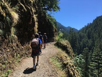 Rear view of people walking on mountain road