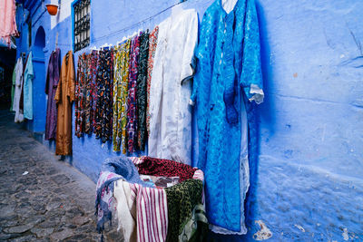 Abayas and scarfs for sale on blue wall, chefchaouen, morocco.