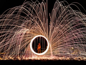 Man standing by wire wool at night