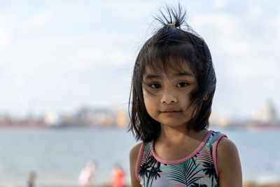 Portrait of cute girl against water