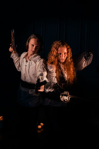 Young couple holding hands against black background