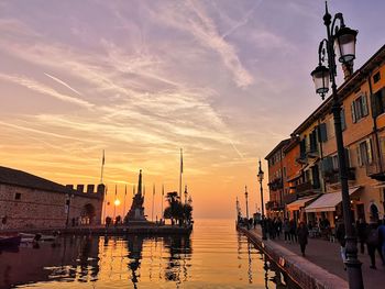 Panoramic view of canal and buildings against sky during sunset