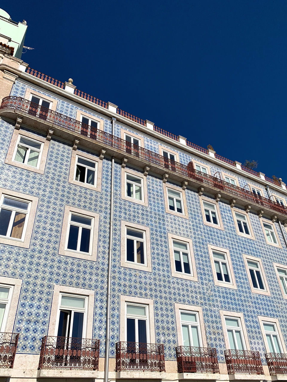 LOW ANGLE VIEW OF BUILDINGS AGAINST CLEAR BLUE SKY