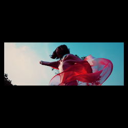 Low angle view of woman standing against sky