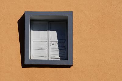Window on the orange facade of the house, architecture in bilbao city, spain
