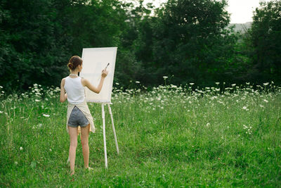 Rear view of woman standing on field