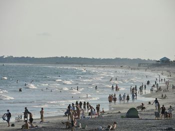 People enjoying at beach during sunny day