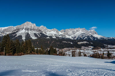 Scenic view of snowcapped mountains against clear blue sky