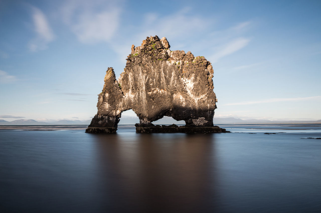 Rock formation in sea against sky