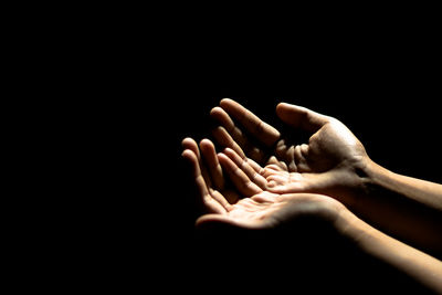 Close-up of human hand gesturing against black background