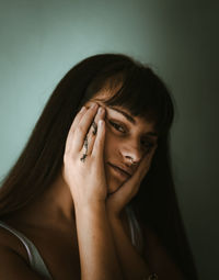 Portrait of beautiful young woman against wall