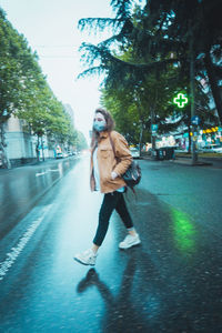 Woman walking on road in city