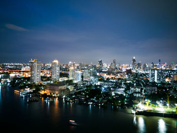 Illuminated cityscape against sky at night