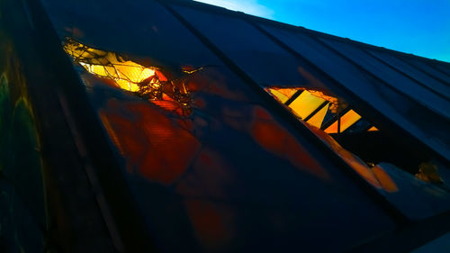 Low angle view of illuminated building against sky during sunset