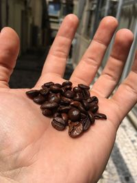 Cropped hand with roasted coffee beans