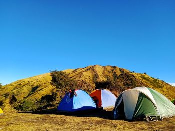Tent on mountain against clear blue sky