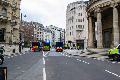 Vehicles on road amidst buildings in city