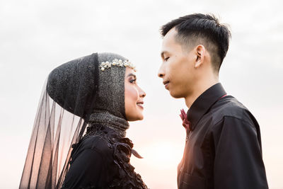 Portrait of young couple against sky