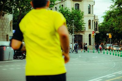 Rear view of people walking on street in city