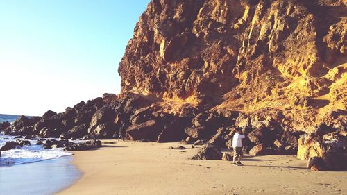 People on shore by cliff