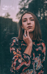 Portrait of beautiful young woman standing against blurred background