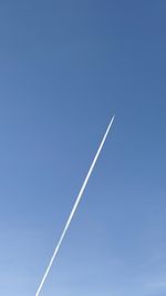 Low angle view of vapor trail against blue sky