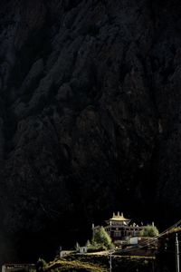 Low angle view of buildings and rock formation at night