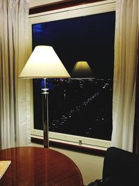 Close-up of illuminated lamp on table at home