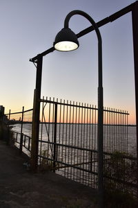 Silhouette of railing at beach during sunset
