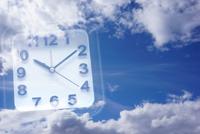 Double exposure of clock and cloudy sky