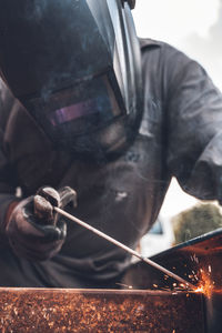 Midsection of man working on barbecue grill