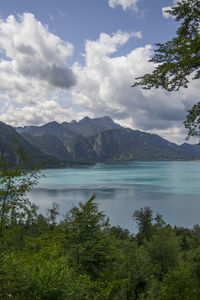 Scenic view of lake by mountains against sky