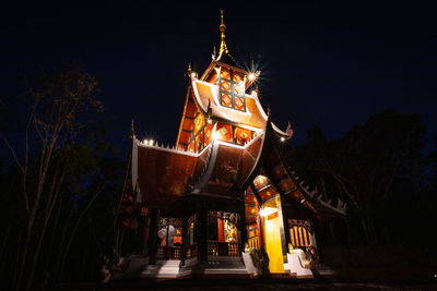 Low angle view of illuminated building against sky at night