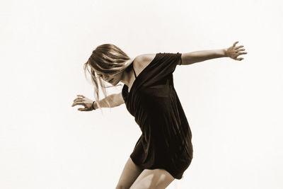 Young woman dancing against white background