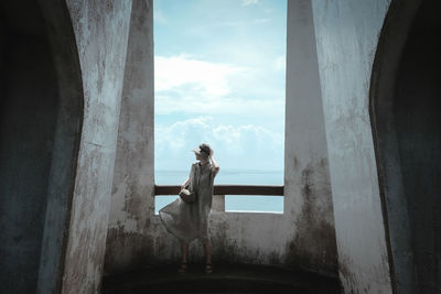 Full length of fashionable woman standing in abandoned building