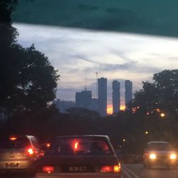 Cars on road in city against sky