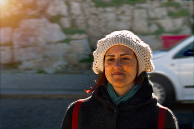 Portrait of young woman standing against wall