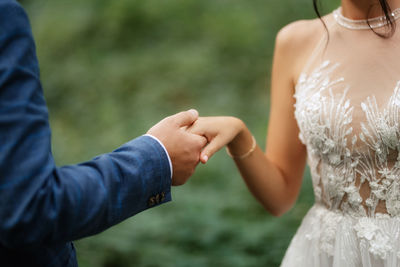 Midsection of bride holding hands