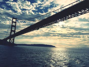 Bridge over sea against sky during sunset