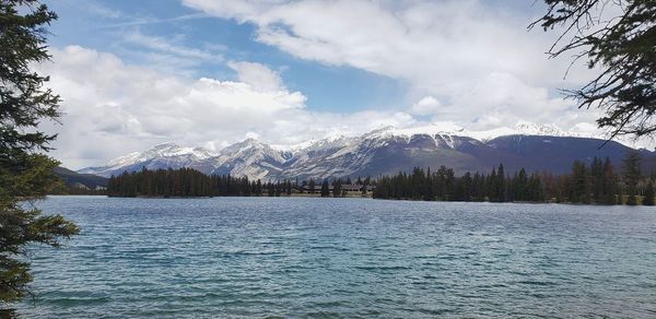 Scenic view of lake by mountains against sky