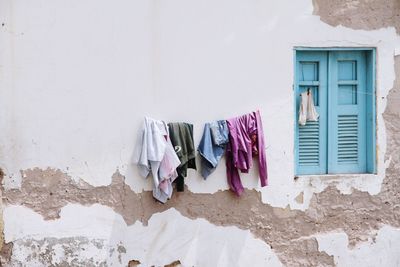 Clothes drying against white wall of old building