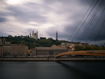 Bridge over river against buildings in city