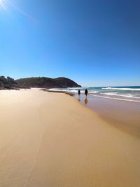 Scenic view of beach against clear blue sky