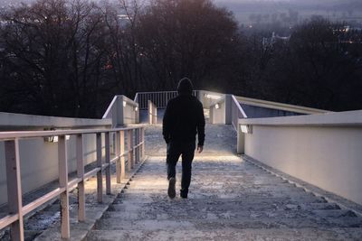 Rear view of man on snow covered bridge