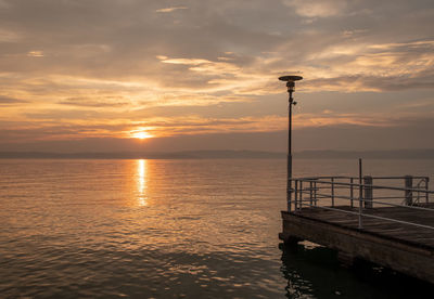 Scenic view of lake garda against sky during sunset