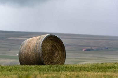 Hay bales on field against sky