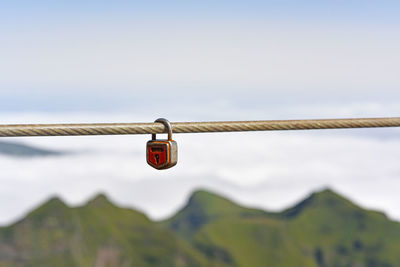 Close-up of padlocks on railing against sky