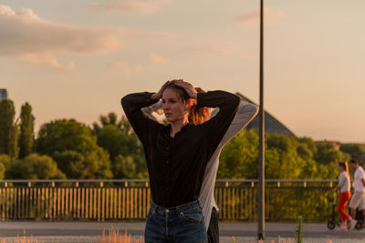 Female friends dancing against sky during sunset